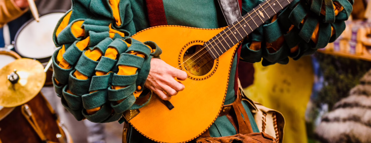 Medieval troubadour playing an antique guitar.