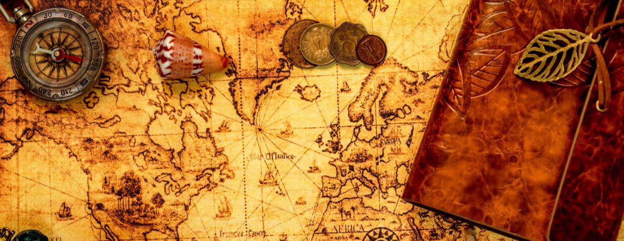 Map being used as a background with coins, a compass and a noteboon on top of it,