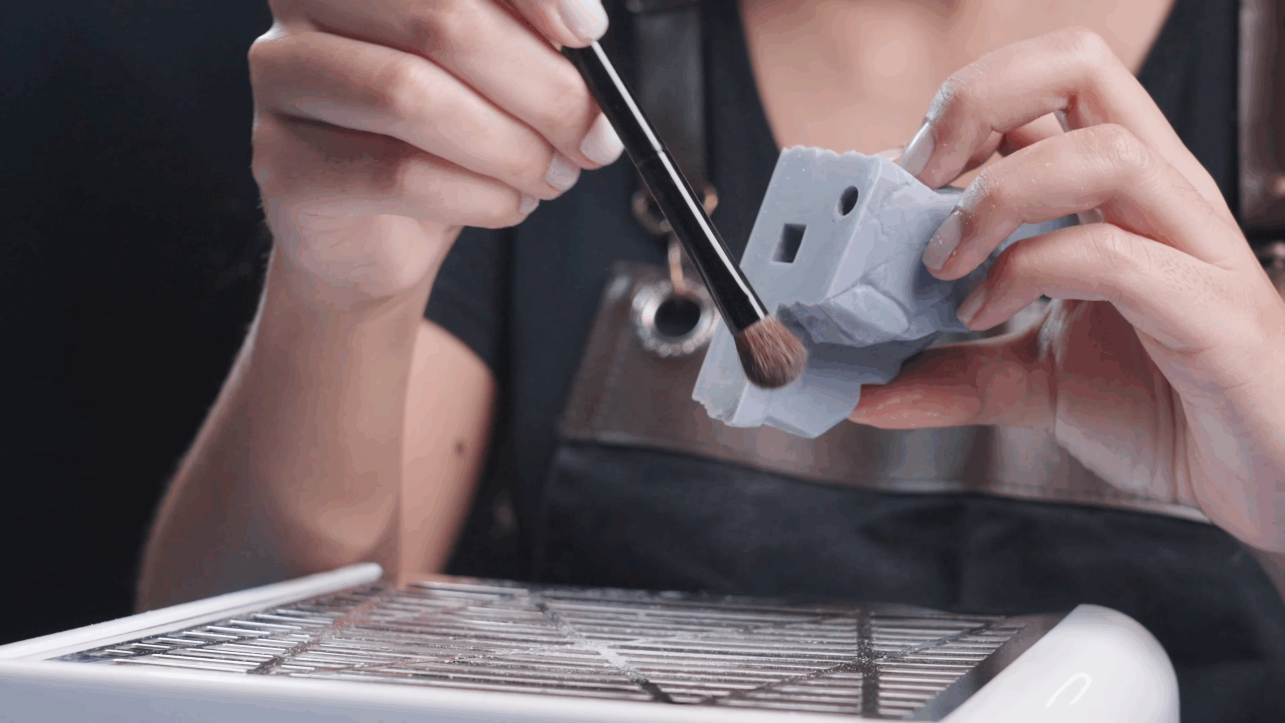 Woman finishing a resin 3D printed terrain from loot studios